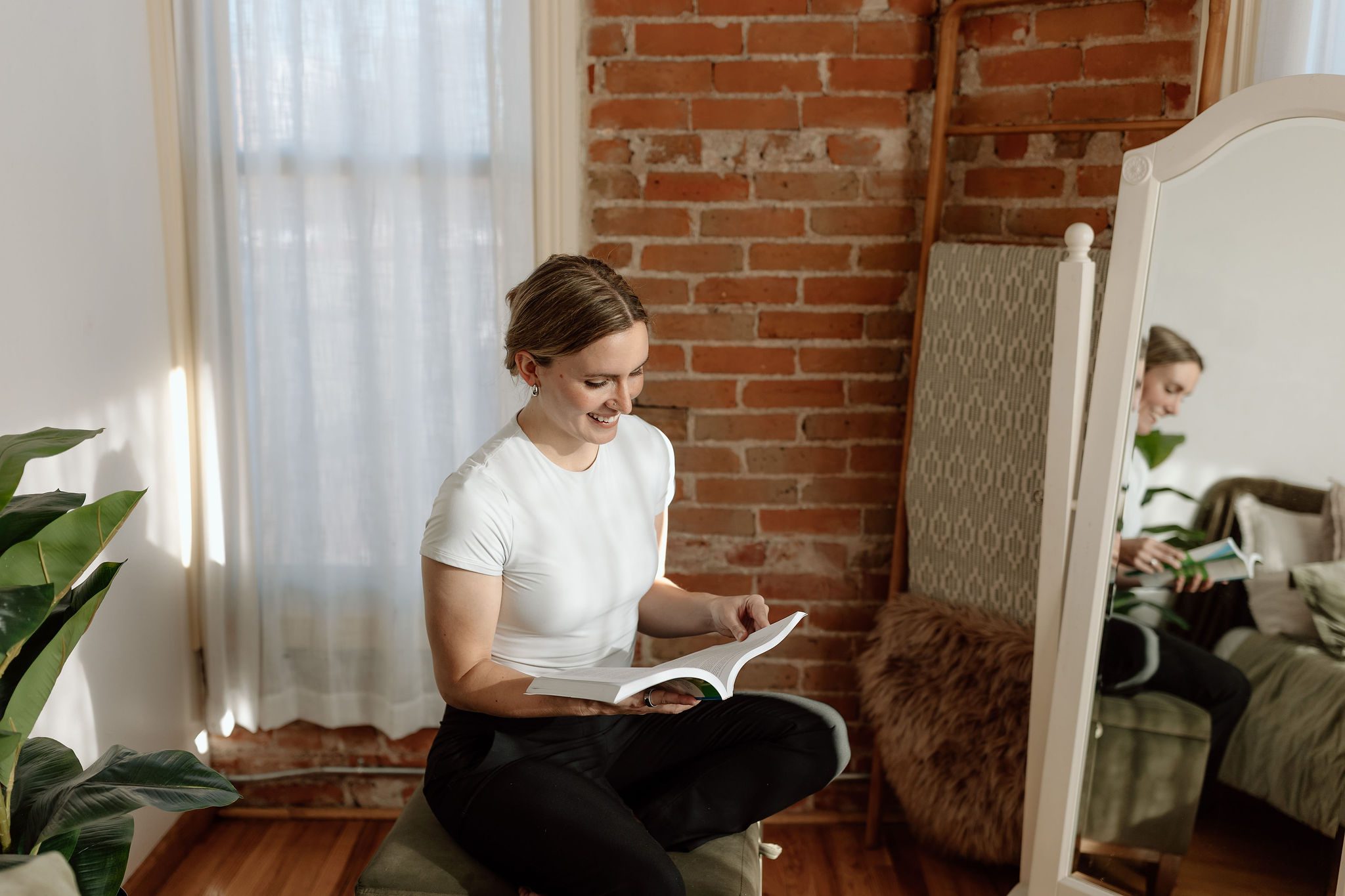woman sitting on a stool reading a book and explaining what a curriculum is