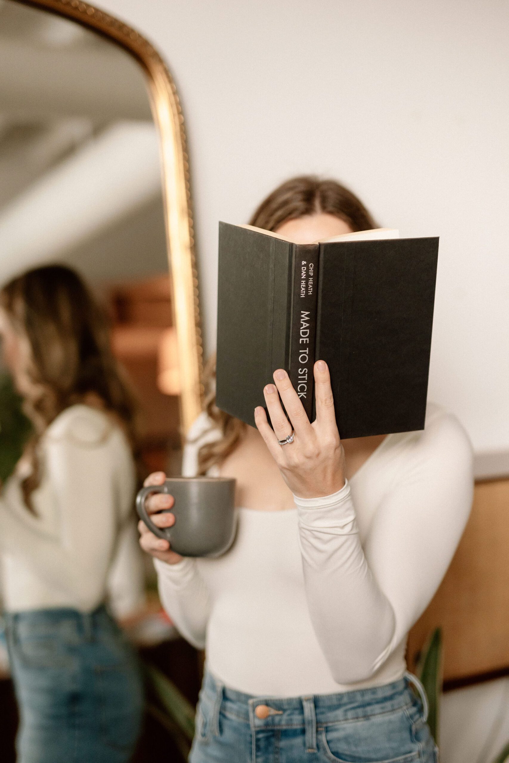 learning specialist lauren dewey holding a book in front of her face while preparing to speak on breaking down text and learning experiences